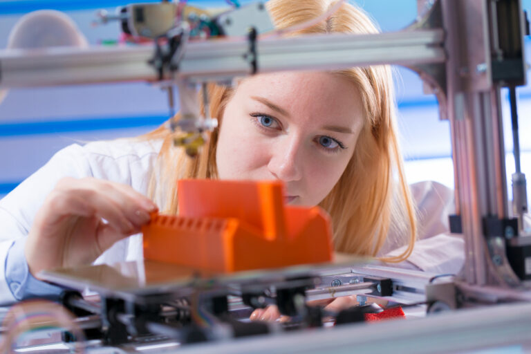 Foto einer Frau, welche sich ein 3D gedrucktes Plastik anschaut